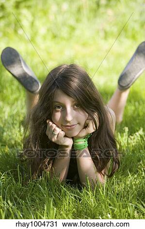 The smiling dark-haired girl-teenager lays on a green lawn in sunlight patchesThe smiling dark-haired girl-teenager lays on a green lawn in sunlight patches View Large Photo Image Stock Image - The smiling dark-haired girl-teenager lays on a green lawn in sunlight patchesThe smiling dark-haired girl-teenager lays on a green lawn in sunlight patches. Fotosearch