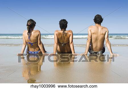 Three best friends seated on the sand having fun on the beach View Large Photo Image Stock Photograph - Three best friends seated on the sand having fun on the beach. Fotosearch