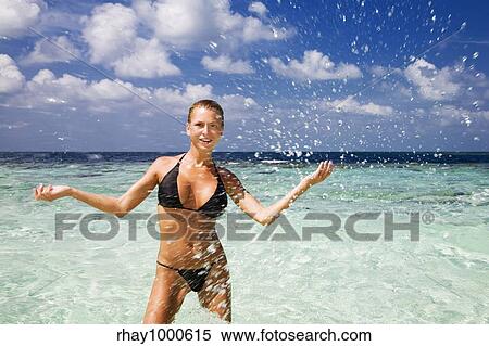Stock Photography - tropical beach: perfect girl playing with water. Copy space. Fotosearch
