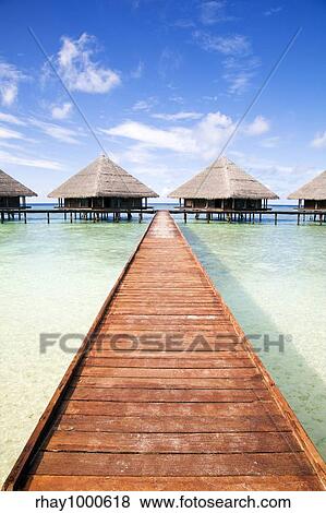 Stock Photo - tropical beach: tropical resort and cloudy sky. Fotosearch