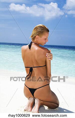 Stock Photo - tropical beach: woman relaxing on a tropical beach. Fotosearch