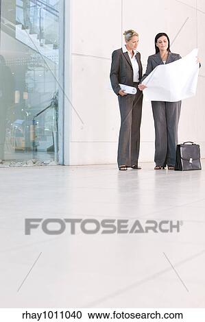 two businesswomen standing outside office building View Large Photo Image Stock Image - two businesswomen standing outside office building. Fotosearch