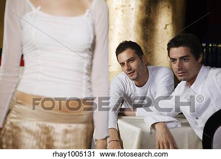 Stock Image - two men admiring woman's bottom. Fotosearch