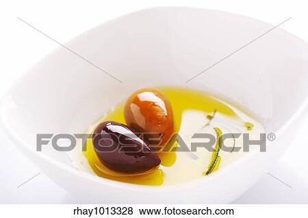 Two olives and olive oil on the white plate View Large Photo Image Stock Photo - Two olives and olive oil on the white plate. Fotosearch
