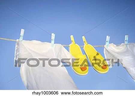 White t-shirts and slippers on the clothesline on a sunny day View Large Photo Image Stock Photograph - White t-shirts and slippers on the clothesline on a sunny day. Fotosearch
