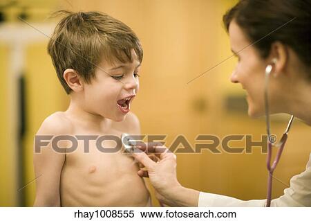 Woman doctor using a stethoscope on talkative boy patient View Large Photo Image Stock Photography - Woman doctor using a stethoscope on talkative boy patient. Fotosearch