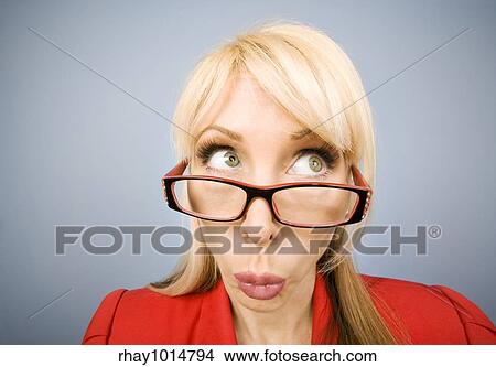 Picture - Woman in red pursing her lips and making a funny face. Fotosearch