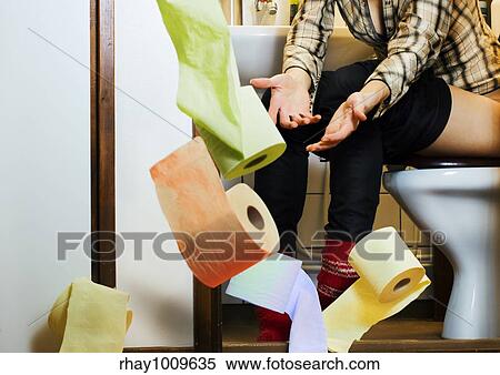Stock Photography - woman on the potty getting tossed with toilet paper she asked for . Fotosearch