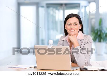 woman sitting at laptop in office View Large Photo Image Stock Photography - woman sitting at laptop in office. Fotosearch