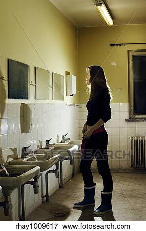 woman standing in abandoned public toilet lookin in teh mirror View Large Photo Image Stock Photo - woman standing in abandoned public toilet lookin in teh mirror. Fotosearch