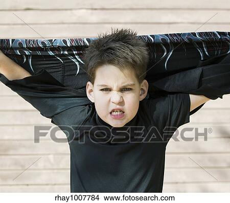 Young boy with his shirt stretched behind his head and a scary look on his face. View Large Photo Image Picture - Young boy with his shirt stretched behind his head and a scary look on his face.. Fotosearch
