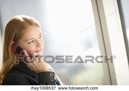 Stock Photo - Young businesswoman talking on cell phone. Fotosearch