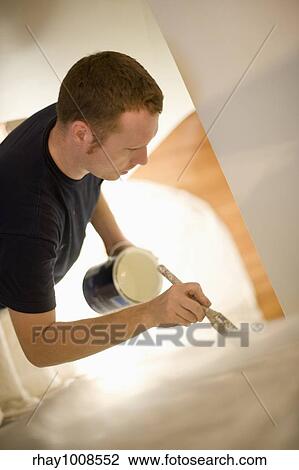 Young man concentrates painting stairway walls View Large Photo Image Stock Image - Young man concentrates painting stairway walls. Fotosearch