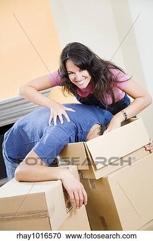 Young playful couple unpacking boxes at new home View Large Photo Image Stock Image - Young playful couple unpacking boxes at new home. Fotosearch