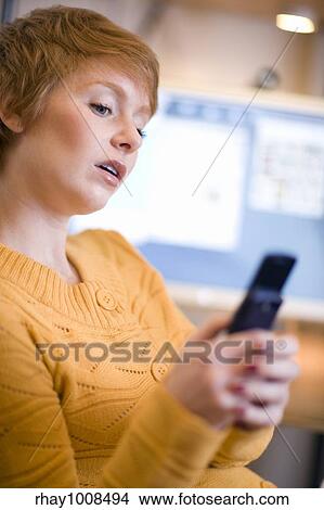 Young woman text messaging on cell phone View Large Photo Image Picture - Young woman text messaging on cell phone. Fotosearch