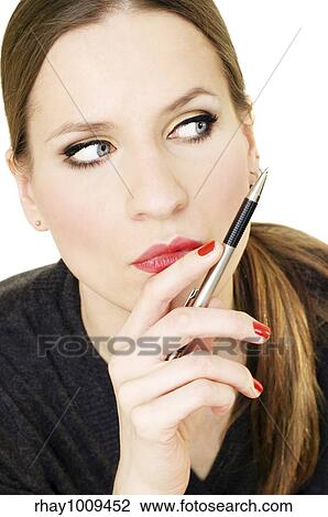 young woman with concentrated expression on her face holding a pen on her lips View Large Photo Image Stock Image - young woman with concentrated expression on her face holding a pen on her lips. Fotosearch