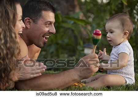 Baby girl with rattle, with mother and grandfather View Large Photo Image Stock Photo - Baby girl with rattle, with mother and grandfather. Fotosearch