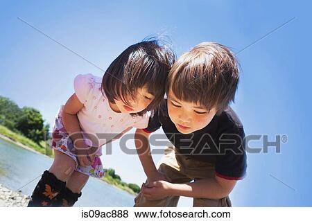 Boy and girl looking down at something View Large Photo Image Stock Photo - Boy and girl looking down at something. Fotosearch