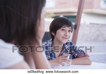 Stock Image - Boy holding drinking glass, smiling. Fotosearch