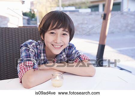 Boy leaning on table with tea light View Large Photo Image Stock Image - Boy leaning on table with tea light. Fotosearch