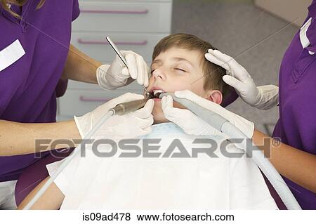 Stock Photo - Boy patient having dental treatment. Fotosearch