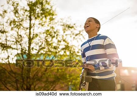 Boy walking with skateboard View Large Photo Image Stock Image - Boy walking with skateboard. Fotosearch