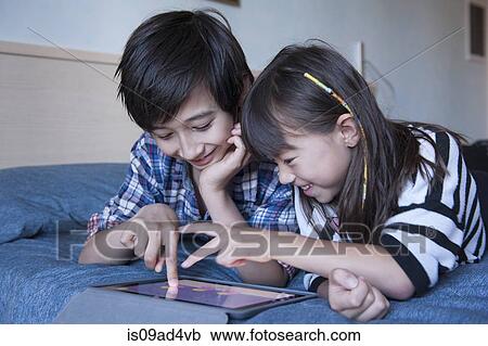 Brother and sister using digital tablet View Large Photo Image Stock Image - Brother and sister using digital tablet. Fotosearch