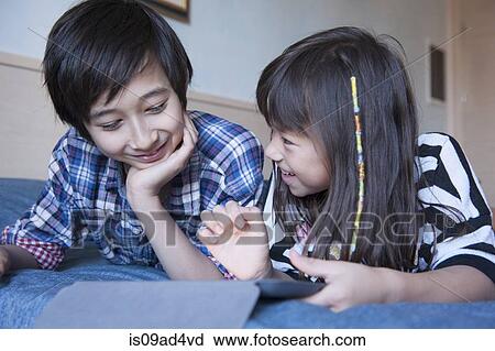 Brother and sister using digital tablet View Large Photo Image Stock Image - Brother and sister using digital tablet. Fotosearch
