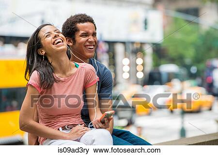 Couple listening to music on mobile phone View Large Photo Image Stock Photo - Couple listening to music on mobile phone. Fotosearch