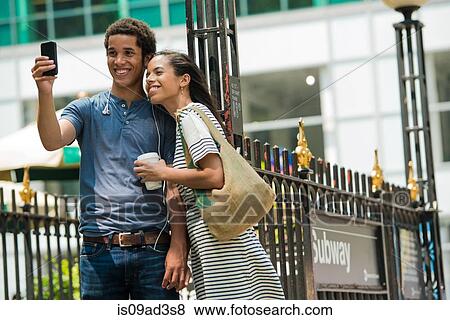 Stock Photo - Couple taking photograph with mobile phone. Fotosearch