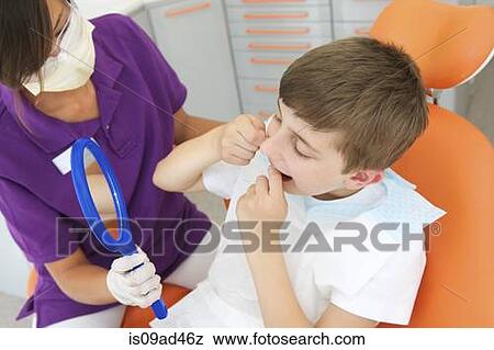 Stock Photo - Dental hygienist holding hand mirror while patient flosses. Fotosearch