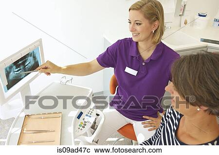 Dentist showing patient xray of dental implants View Large Photo Image Stock Image - Dentist showing patient xray of dental implants. Fotosearch