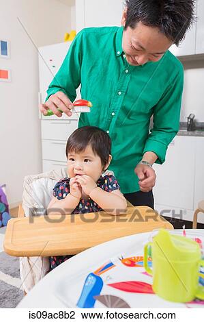 Stock Image - Father combing baby's hair. Fotosearch