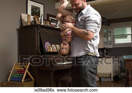 Father holding daughter upside down View Large Photo Image Stock Photograph - Father holding daughter upside down. Fotosearch