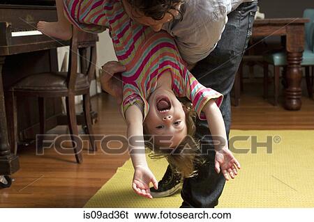 Father holding daughter upside down View Large Photo Image Stock Photograph - Father holding daughter upside down. Fotosearch