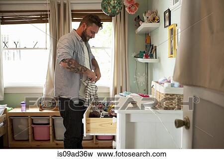 Stock Photo - Father putting away child's laundry. Fotosearch