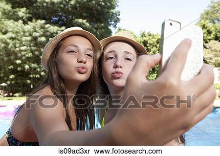 Stock Photography - Friends self photographing with mobile phone. Fotosearch