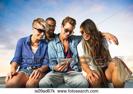 Friends sitting on wall with smartphone, San Diego, California, USA View Large Photo Image Stock Image - Friends sitting on wall with smartphone, San Diego, California, USA. Fotosearch