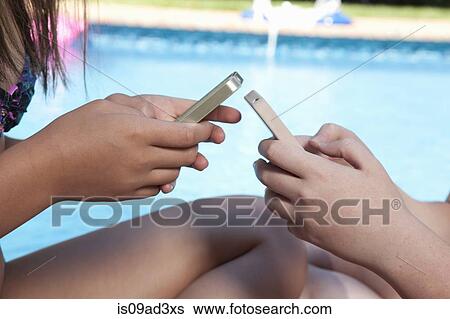 Friends texting on mobile phone View Large Photo Image Stock Photograph - Friends texting on mobile phone. Fotosearch