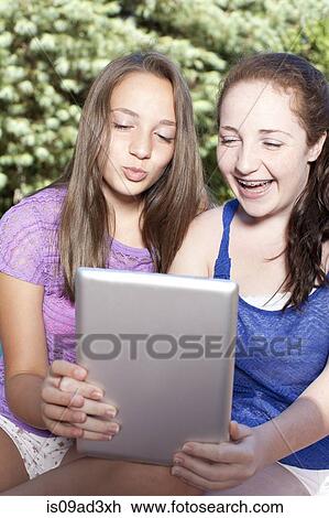 Stock Image - Friends using digital tablet. Fotosearch