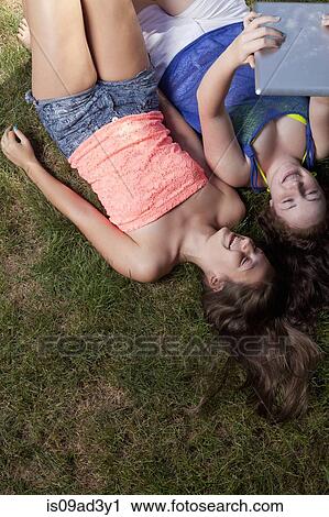 Friends using digital tablet View Large Photo Image Stock Image - Friends using digital tablet. Fotosearch