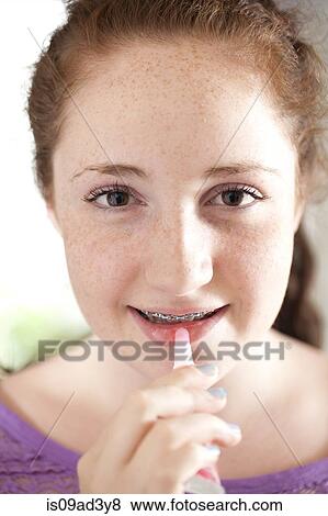 Girl applying lip gloss View Large Photo Image Stock Photo - Girl applying lip gloss. Fotosearch