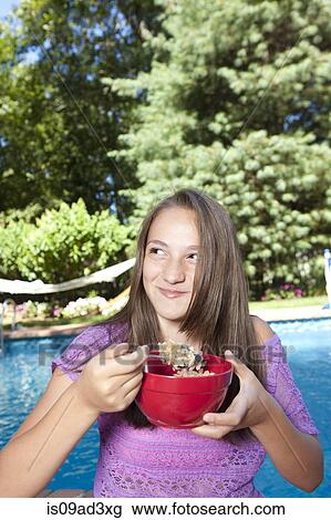 Girl eating by pool View Large Photo Image Stock Image - Girl eating by pool. Fotosearch