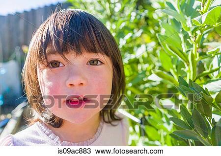 Stock Image - Girl in fava bean garden. Fotosearch