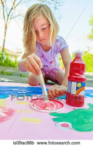 Stock Image - Girl painting with tempera on paper. Fotosearch