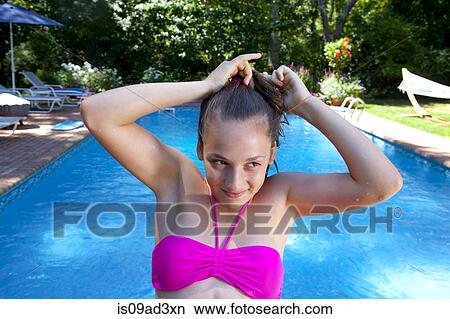 Girl tying hair by pool View Large Photo Image Picture - Girl tying hair by pool. Fotosearch