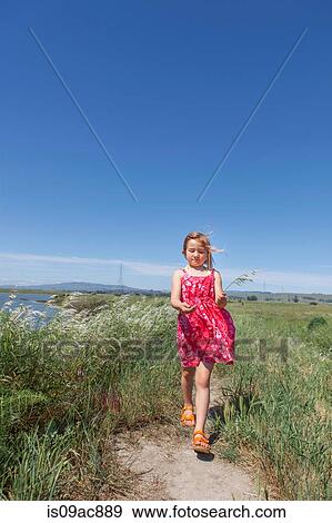 Girl walking by river marsh View Large Photo Image Stock Photo - Girl walking by river marsh. Fotosearch