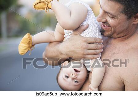 Grandfather holding baby granddaughter upside down View Large Photo Image Stock Image - Grandfather holding baby granddaughter upside down. Fotosearch
