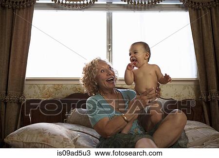 Stock Image - Grandmother holding baby granddaughter. Fotosearch