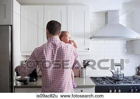 Man holding baby and making cup of coffee View Large Photo Image Stock Photograph - Man holding baby and making cup of coffee. Fotosearch